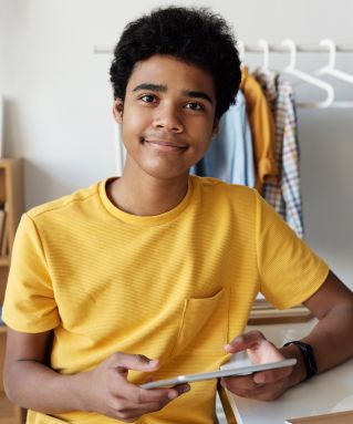 Two professional women smiling and embracing in a modern office environment, symbolizing teamwork and friendship.